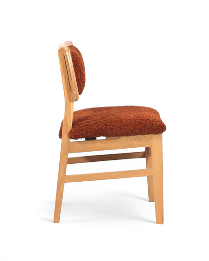 Rustic accent chair with burnt orange shearling-style upholstery and natural wood frame, ideal for modern farmhouse or boho interiors.