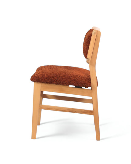 Rustic accent chair with burnt orange shearling-style upholstery and natural wood frame, ideal for modern farmhouse or boho interiors.