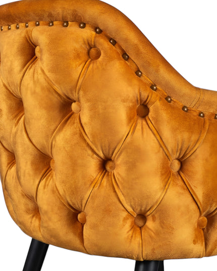 Orange velvet accent chair with tufted arm detailing and tapered wooden legs — ideal for modern dining rooms, vanity seating, or boutique interiors.