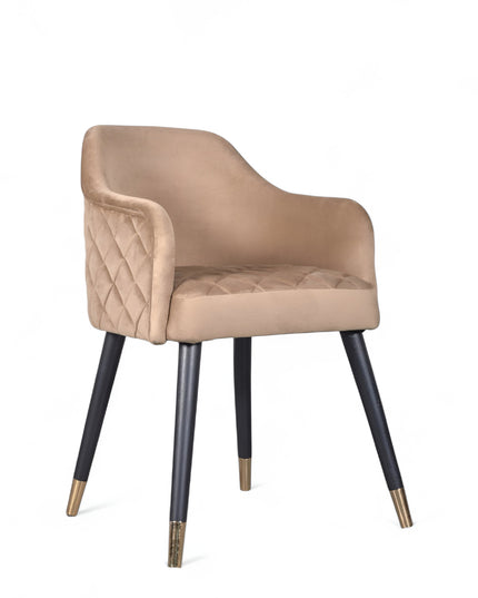 Upholstered beige armchair with diamond stitching, enclosed sides, and tapered black legs with golden tips