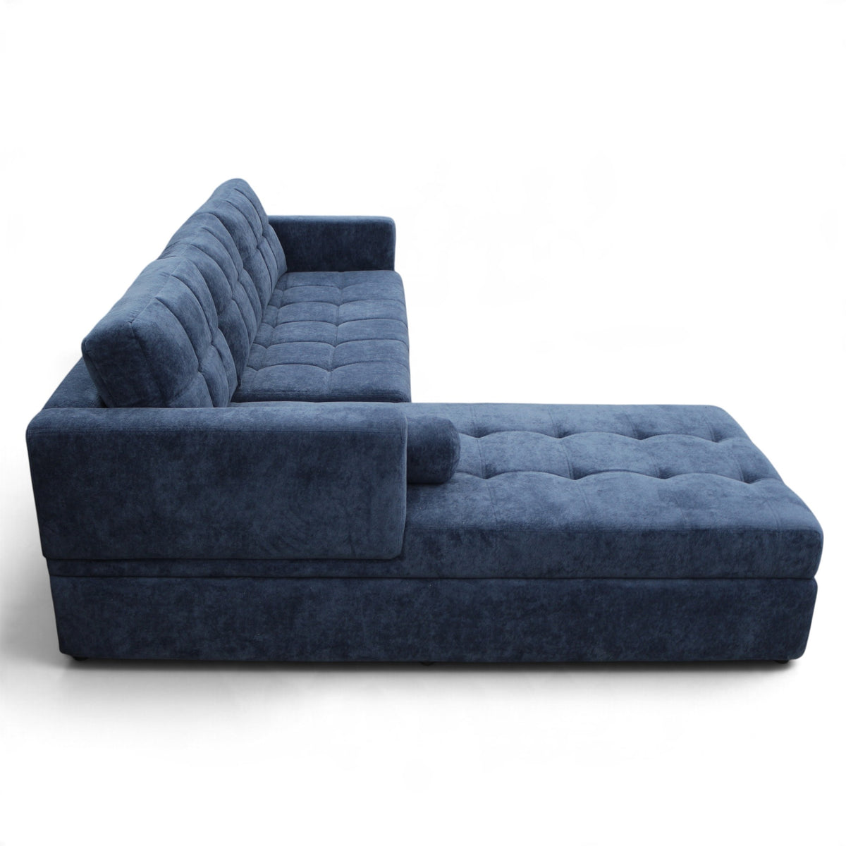 A modern sectional sofa with a chaise lounge, upholstered in a textured navy blue velvet fabric, shown from a side profile view on a white background.