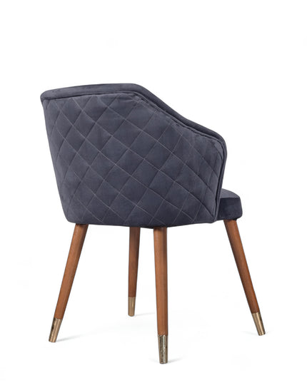 Elegant upholstered dark blue chair with quilted sides, curved backrest, and metal-tipped wooden legs

