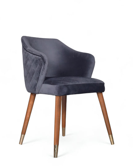Elegant upholstered dark blue chair with quilted sides, curved backrest, and metal-tipped wooden legs

