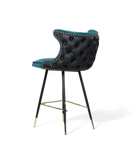 Modern bar stool with a sculpted teal velvet seat and high backrest, featuring black tufted faux leather on the outer back, brass nailhead trim, and slim black metal legs with gold accents and a footrest-ideal for kitchen islands or stylish bar areas