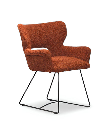 Modern rust orange bouclé accent chair with curved backrest and black metal sled base, perfect for contemporary or eclectic home decor.
