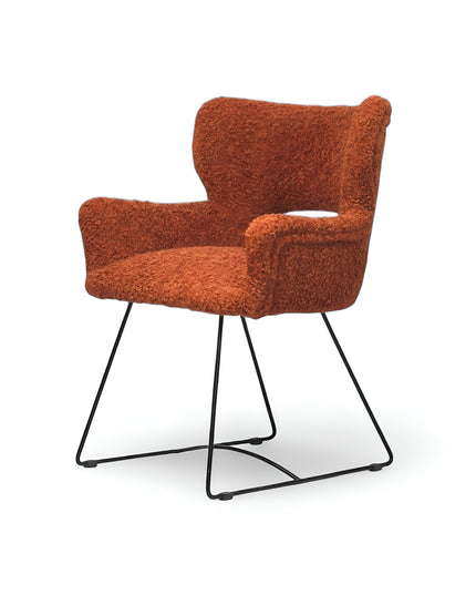 Modern rust orange bouclé accent chair with curved backrest and black metal sled base, perfect for contemporary or eclectic home decor.