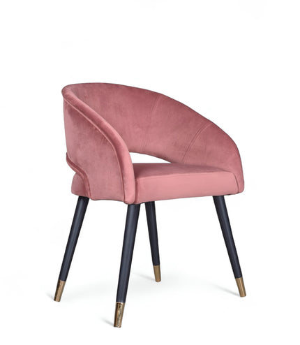Curved-back pink modern chair with wraparound design, cushioned seat, and brass-tipped black legs