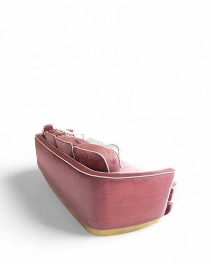 Pink velvet sofa with gold base on a white background
