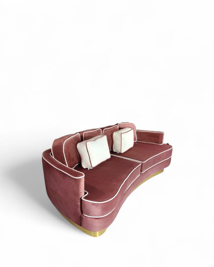 Pink velvet sofa with gold base on a white background