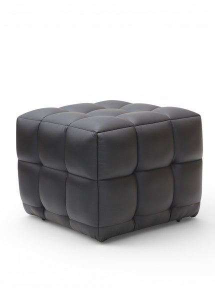 A modern square ottoman with a tufted grid pattern, upholstered in dark charcoal gray leather, shown on a clean white background.