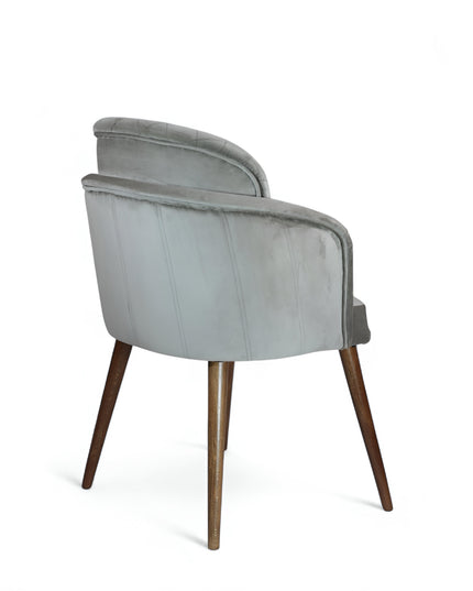 Modern dining chair with light grey diamond-stitched velvet upholstery and angled walnut wooden legs — ideal for contemporary interiors and luxury dining spaces.