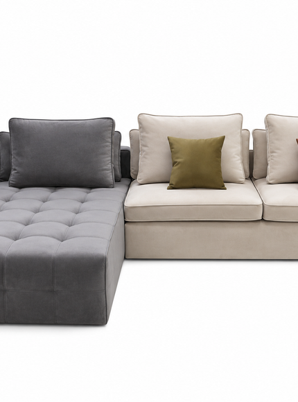 A modern sectional sofa with a tufted gray chaise lounge on the left, connected to a light beige three-seat section with cream cushions and two accent pillows in olive green and rust brown, shown on a white background.
