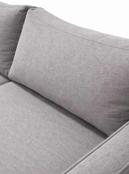 closeup of light gray fabric sectional sofa, highlighting the textured upholstery, plush back cushion, and clean stitched seams under soft, even lighting.