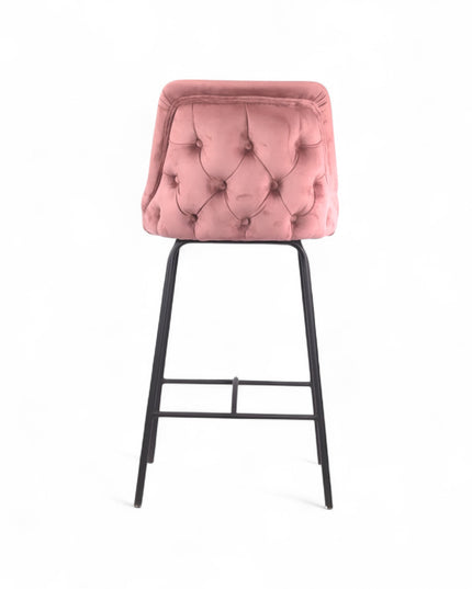 Modern bar stool with a high backrest and seat upholstered in blush pink velvet, featuring button-tufted detailing and slim black metal legs with a built-in footrest, ideal for kitchen islands or contemporary bar spaces