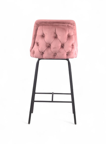 Modern bar stool with a high backrest and seat upholstered in blush pink velvet, featuring button-tufted detailing and slim black metal legs with a built-in footrest, ideal for kitchen islands or contemporary bar spaces