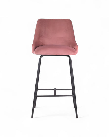 Modern bar stool with a high backrest and seat upholstered in blush pink velvet, featuring button-tufted detailing and slim black metal legs with a built-in footrest, ideal for kitchen islands or contemporary bar spaces