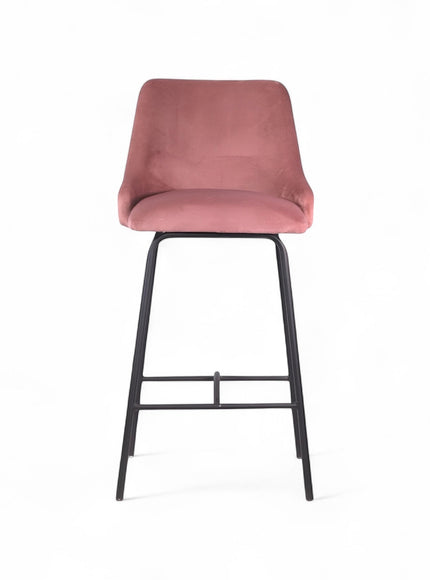 Modern bar stool with a high backrest and seat upholstered in blush pink velvet, featuring button-tufted detailing and slim black metal legs with a built-in footrest, ideal for kitchen islands or contemporary bar spaces