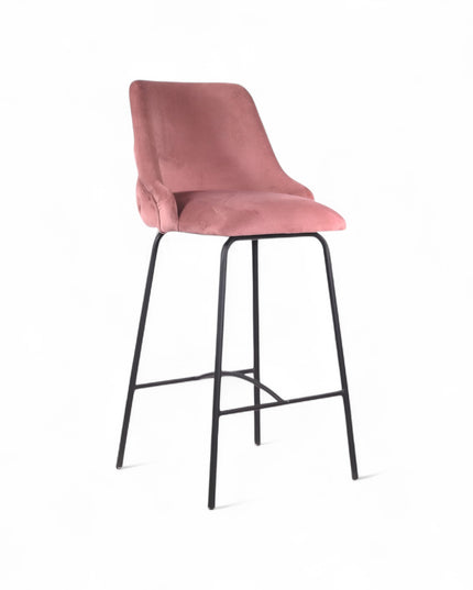 Modern bar stool with a high backrest and seat upholstered in blush pink velvet, featuring button-tufted detailing and slim black metal legs with a built-in footrest, ideal for kitchen islands or contemporary bar spaces