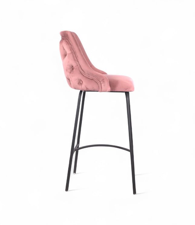 Modern bar stool with a high backrest and seat upholstered in blush pink velvet, featuring button-tufted detailing and slim black metal legs with a built-in footrest, ideal for kitchen islands or contemporary bar spaces