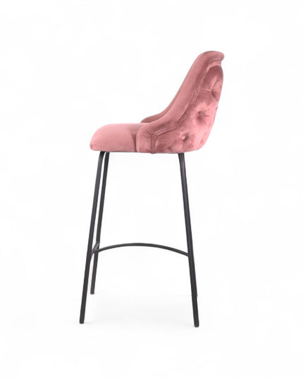 Modern bar stool with a high backrest and seat upholstered in blush pink velvet, featuring button-tufted detailing and slim black metal legs with a built-in footrest, ideal for kitchen islands or contemporary bar spaces