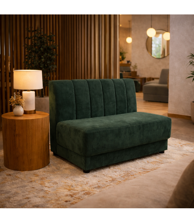 Green sofa in a living room setting with a wooden side table and lamp.