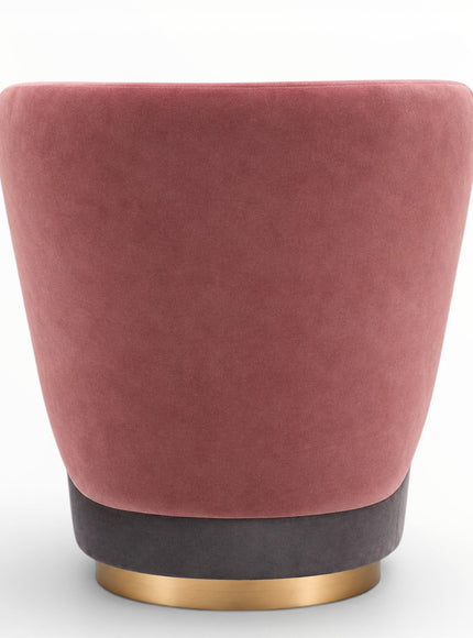 A modern tapered velvet armchair in dusty rose pink, featuring a dark charcoal gray base accented by a polished gold circular metal ring, set against a plain white background.
