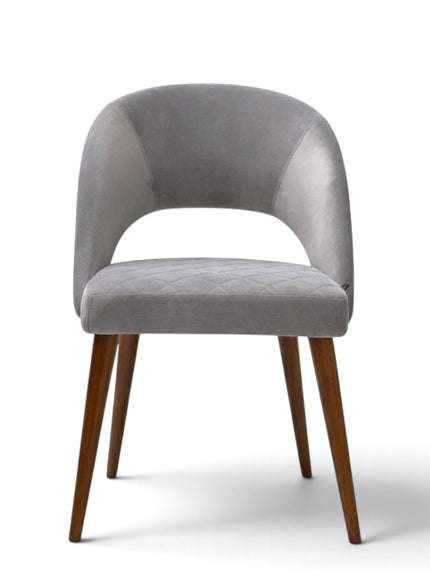 Argent grey upholstered dining chair with curved open backrest, diamond-quilted seat and brown wooden legs.