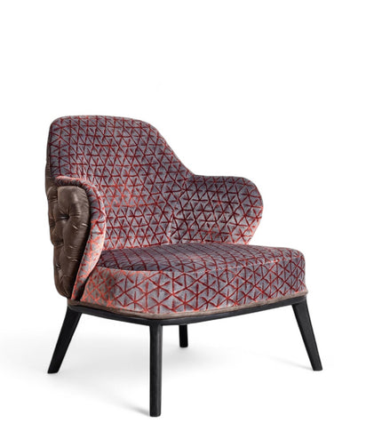 Array armchair with geometric fabric upholstery, deep button-tufted leather-look back, and black tapered wooden legs.