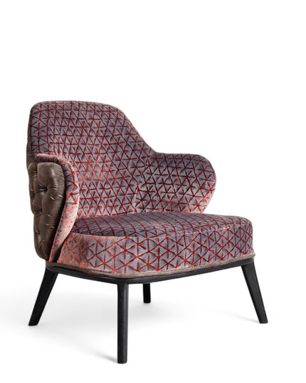 Array armchair with geometric fabric upholstery, deep button-tufted leather-look back, and black tapered wooden legs.