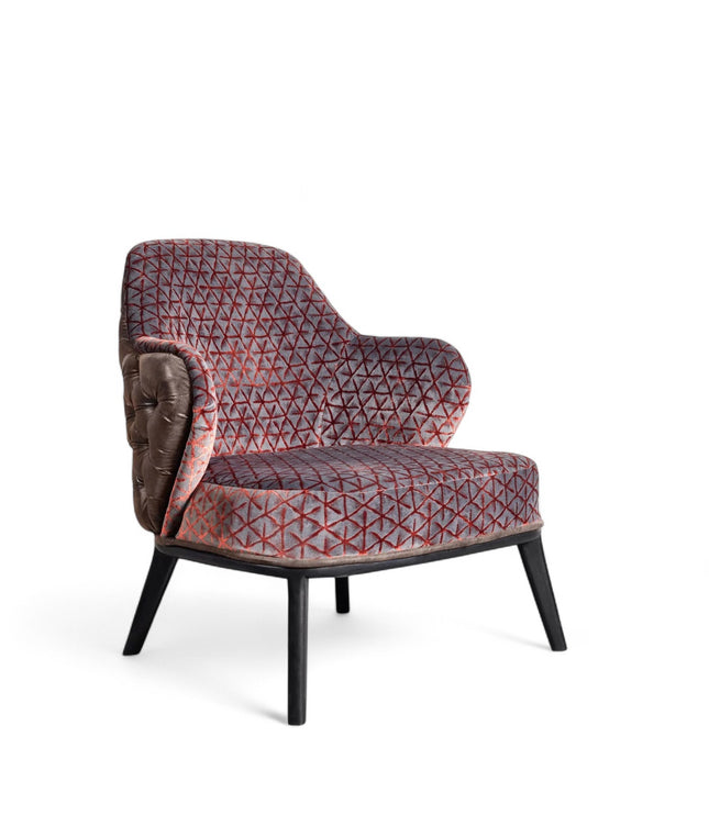 Array armchair with geometric fabric upholstery, deep button-tufted leather-look back, and black tapered wooden legs.