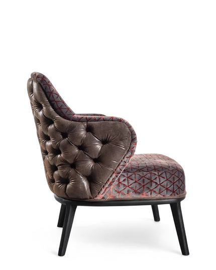 Array armchair with geometric fabric upholstery, deep button-tufted leather-look back, and black tapered wooden legs.