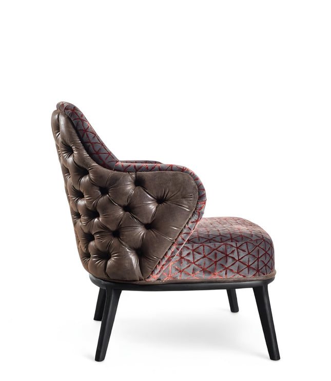 Array armchair with geometric fabric upholstery, deep button-tufted leather-look back, and black tapered wooden legs.