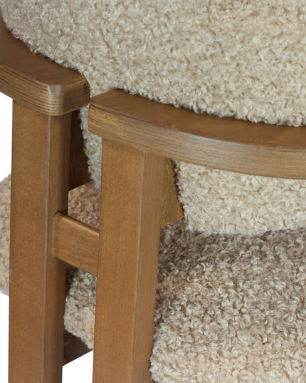 Modern wooden chair with beige boucle upholstery, featuring cushioned seat, rounded backrest, and minimalist armrests.