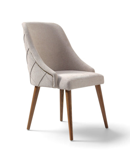 A modern upholstered dining chair with a light beige fabric seat and curved backrest, featuring geometric stitched detailing on the side, supported by four tapered wooden legs, shown on a white background.