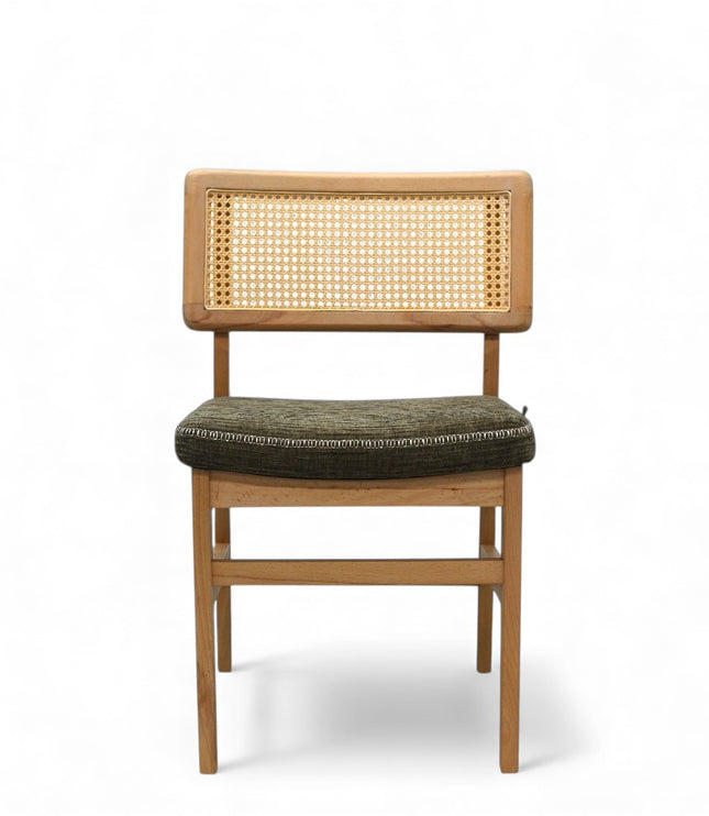Close-up of a wooden chair with a woven rattan backrest and a textured green upholstered seat.