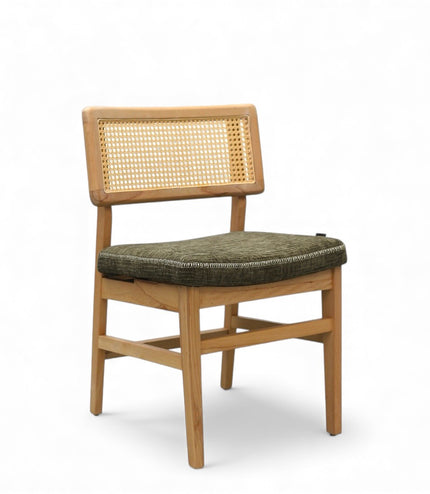 Close-up of a wooden chair with a woven rattan backrest and a textured green upholstered seat.