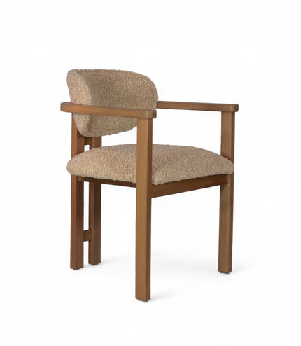Modern wooden chair with beige boucle upholstery, featuring cushioned seat, rounded backrest, and minimalist armrests.