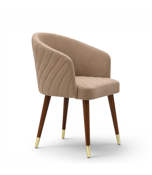 A modern dining chair with a curved, tufted backrest and seat upholstered in a warm taupe-beige fabric, supported by four tapered dark brown wooden legs with gold metal caps, shown against a plain white background.