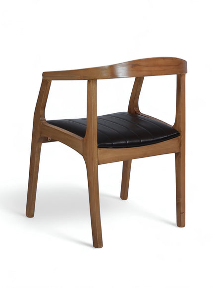 Rear angled view of the Vaya Home Abre dining chair featuring a wood frame, open back design, and black upholstered seat.