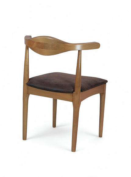 Front angled view of the Vaya Home Albero dining chair featuring a sculpted wood backrest and brown upholstered seat.