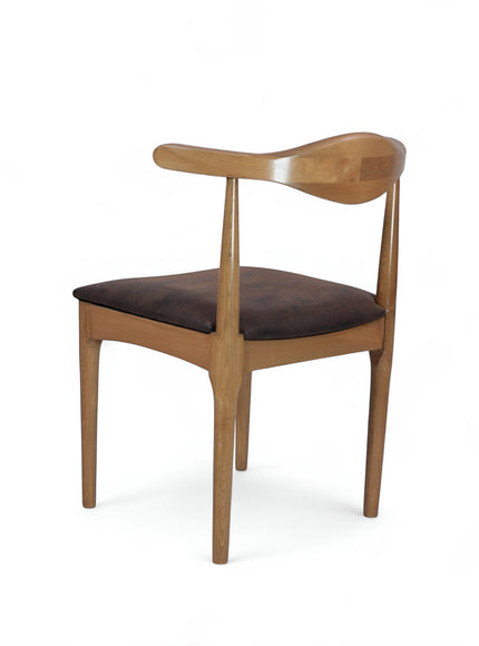Rear angled view of the Vaya Home Albero dining chair with a sculpted wood frame and brown upholstered seat.