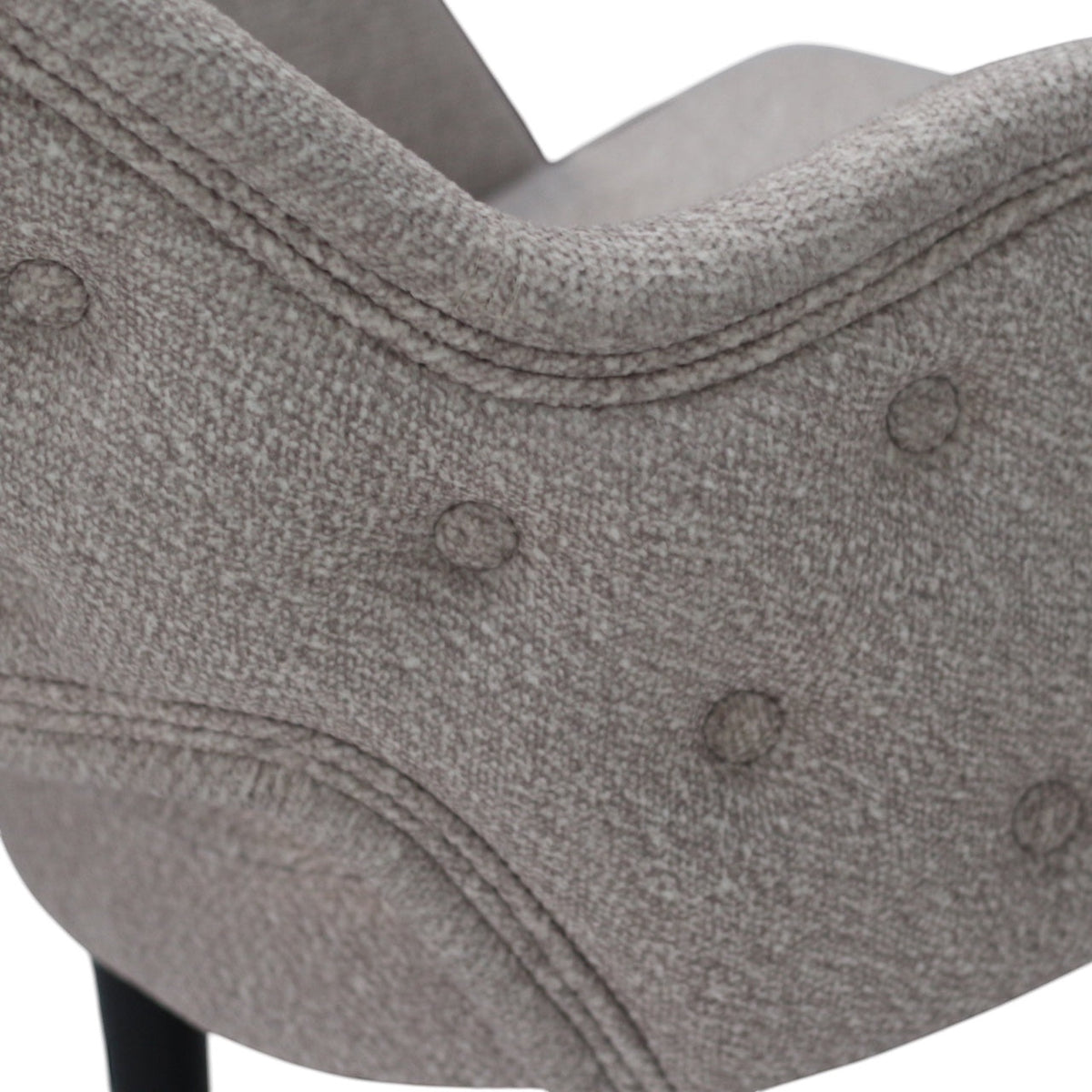 Close-up of the Vaya Home Alt dining chair showing beige upholstery, button tufting, and curved backrest detail.