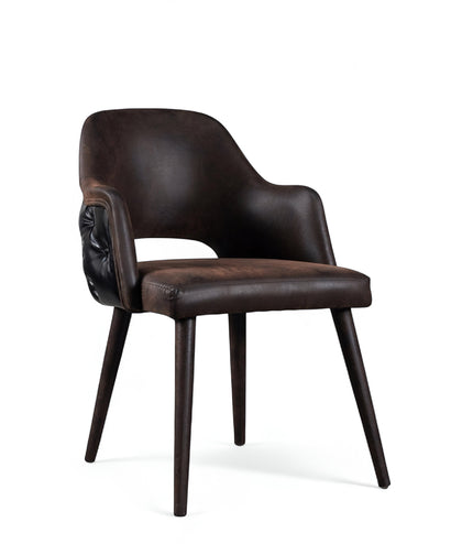 Front angled view of the Vaya Home Alt dining chair with dark brown leather upholstery, integrated arms, and tapered wood legs.