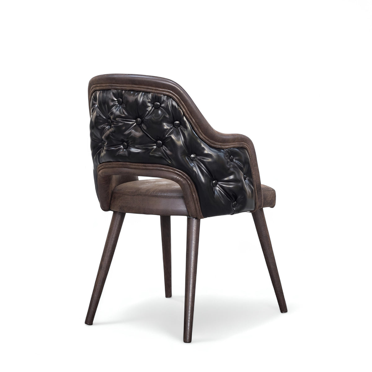 Rear angled view of the Vaya Home Alt dining chair with dark brown leather upholstery, button-tufted outer back, curved arms, and tapered wood legs.