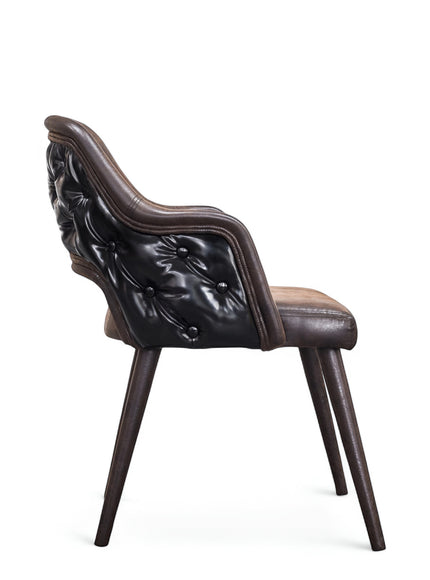 Side rear view of the Vaya Home Alt dining chair featuring dark brown leather upholstery, a curved button-tufted back, and tapered wood legs.