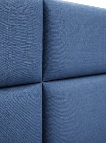 Close-up of the Vaya Home Alturo bed headboard showing blue upholstered panels and stitched detailing.