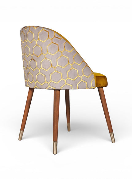 Rear angled view of the Vaya Home Alveare dining chair featuring a gray geometric patterned outer back, yellow seat upholstery, and tapered wood legs.