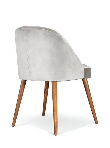 Rear angled view of the Vaya Home Alveare dining chair with gray upholstery and tapered wood legs.