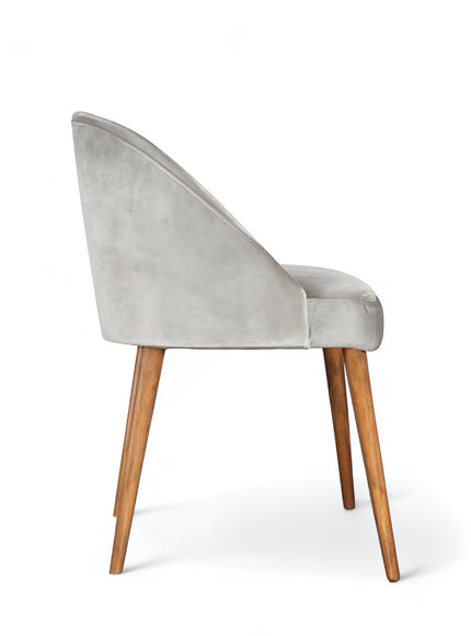 Side view of the Vaya Home Alveare dining chair featuring gray upholstery and tapered wood legs.