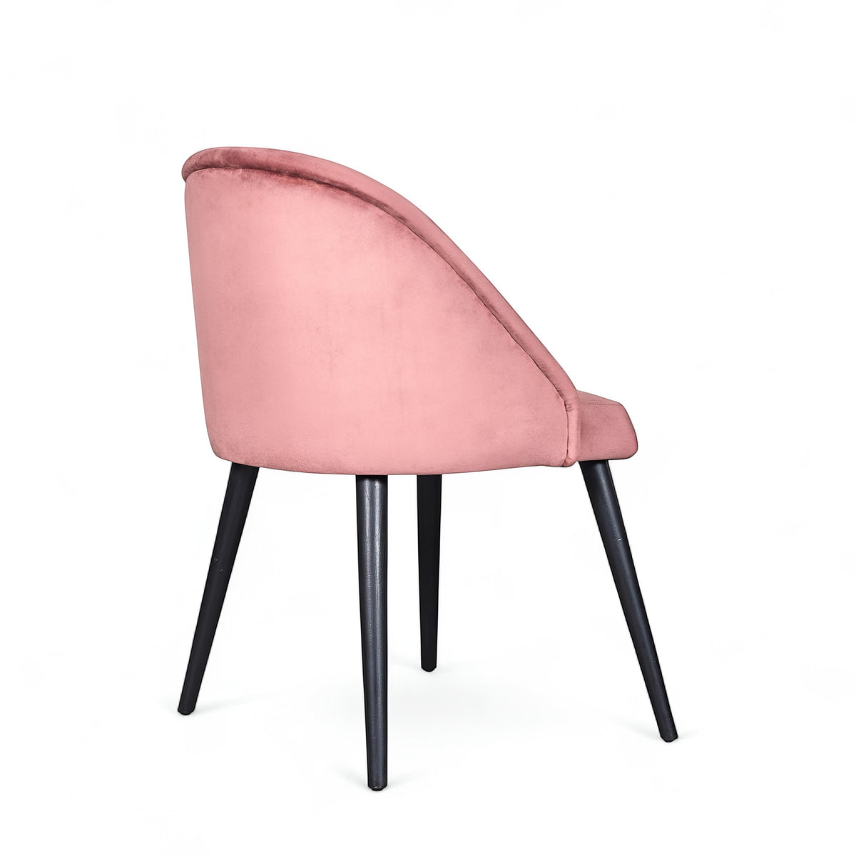 Rear angled view of the Vaya Home Alveare dining chair featuring pink upholstery and black tapered legs.